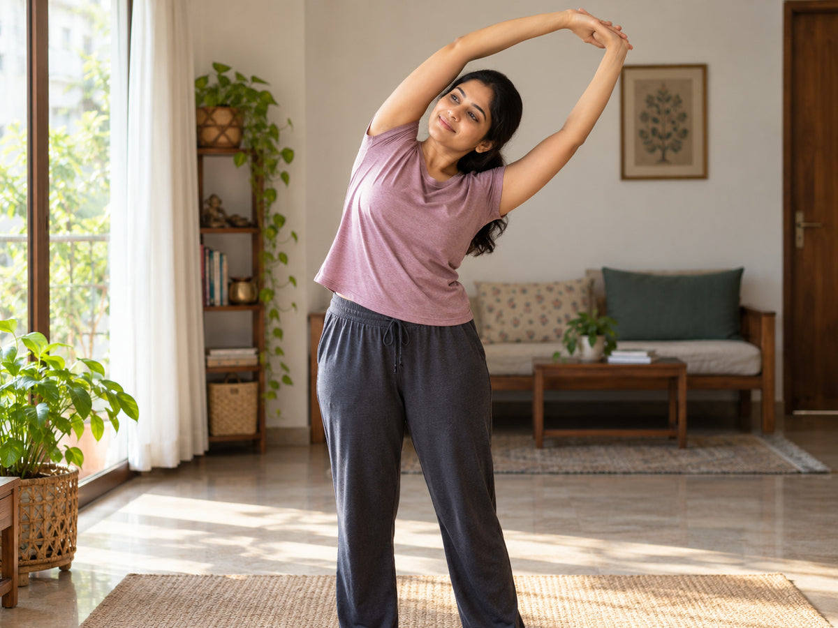 Indian woman doing a gentle stretch in a sunlit home